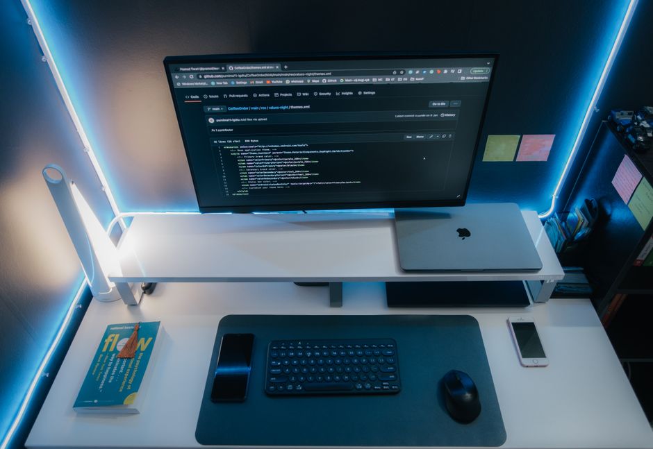 Minimalistički computer setup s neonskim svjetlom