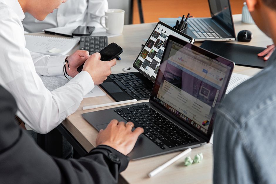 Profesionalci u modernom uredu razgovaraju s laptopima
